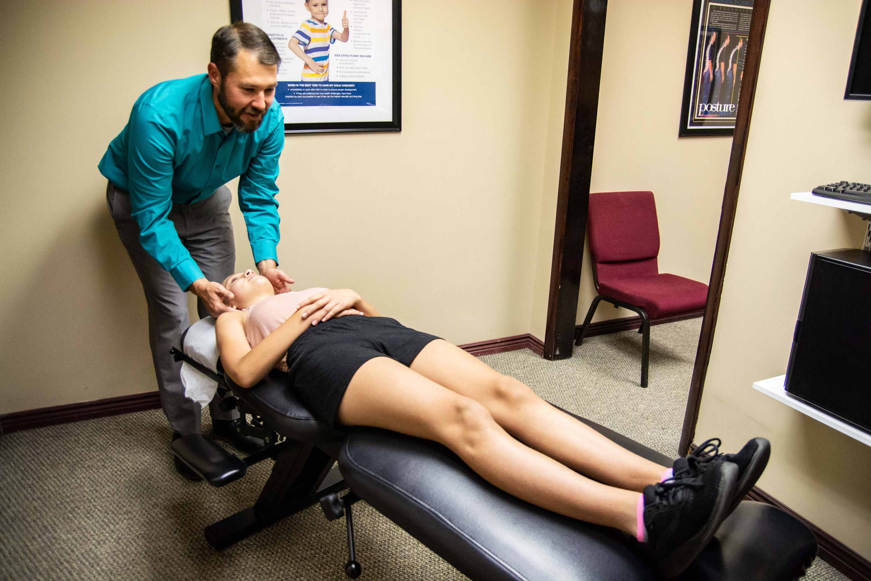 A chiropractor adjusting a woman's neck